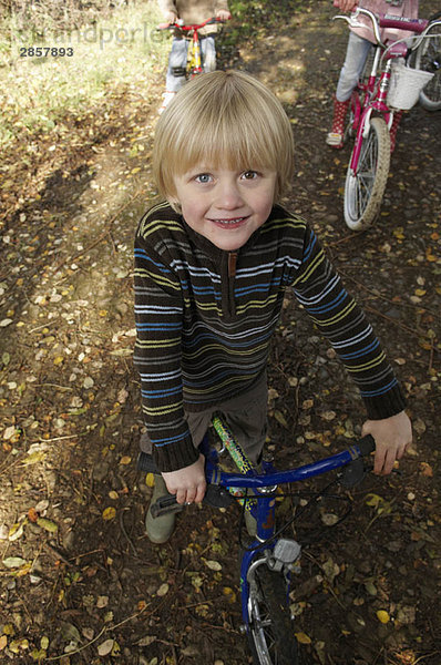 Kleiner Junge auf dem Fahrrad auf dem Landweg