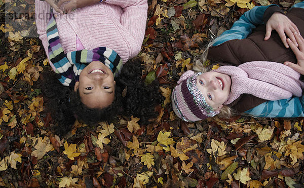 Zwei Freunde auf Herbstblättern liegend