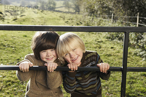 Zwei kleine Jungen am Tor auf dem Lande