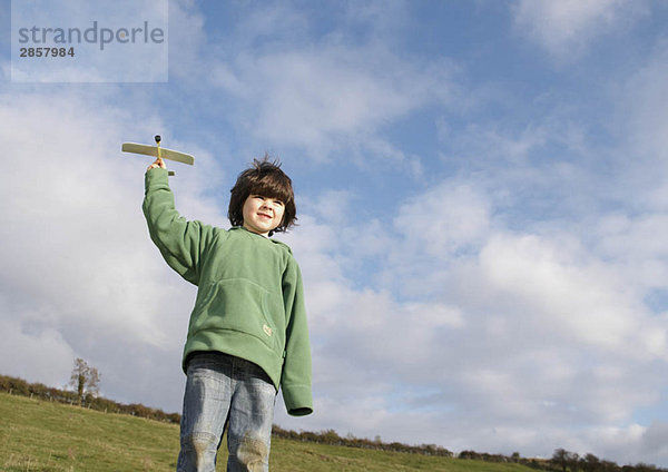 Young Boy mit Spielzeugflugzeug im Feld