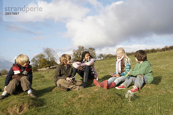 Kindergruppe auf dem Hügel sitzend