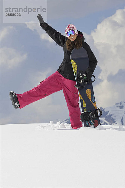 Weibliche Snowboarderin beim Herumspielen im