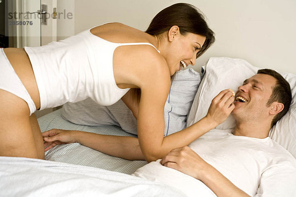 Junges Paar zu Hause entspannt im Bett