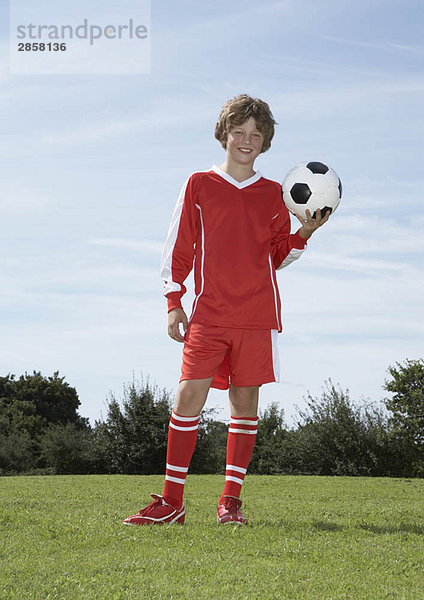 Junger männlicher Fußballspieler mit einem Ball