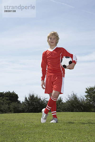 Junger männlicher Fußballspieler mit einem Ball