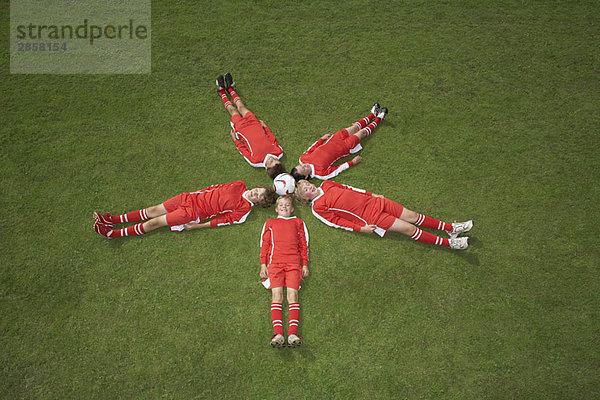 Fußballspieler  die um einen Ball herum liegen