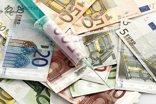 Euro-Banknoten und Spritze mit Euro-Schein