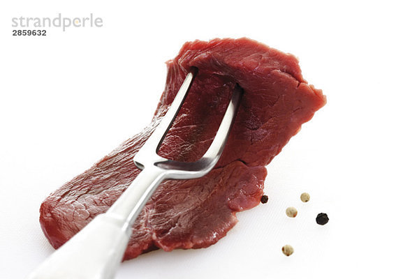 Raw Minute Steak und Fleischgabel  Nahaufnahme
