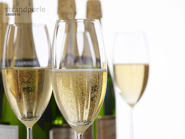 Champagnerflaschen und Champagnergläser im Vordergrund  Nahaufnahme