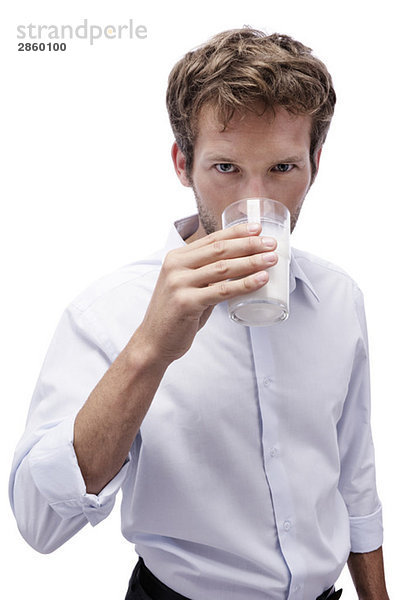 Junger Mann trinkt ein Glas Milch  Porträt