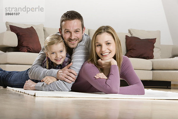 Parents with daughter (3-4)  relaxing at home