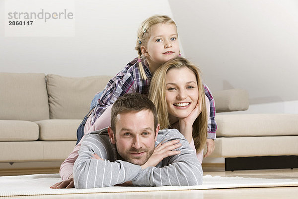 Eltern und Tochter (3-4) entspannt zu Hause