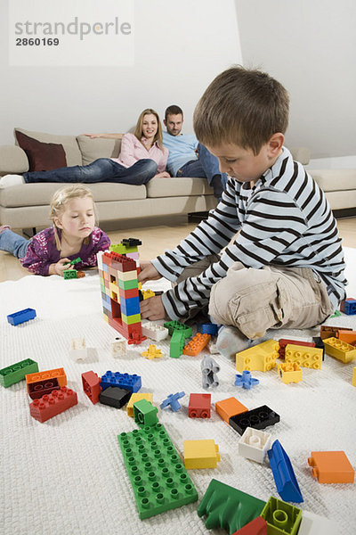 Family relaxing at home  children playing with building bricks
