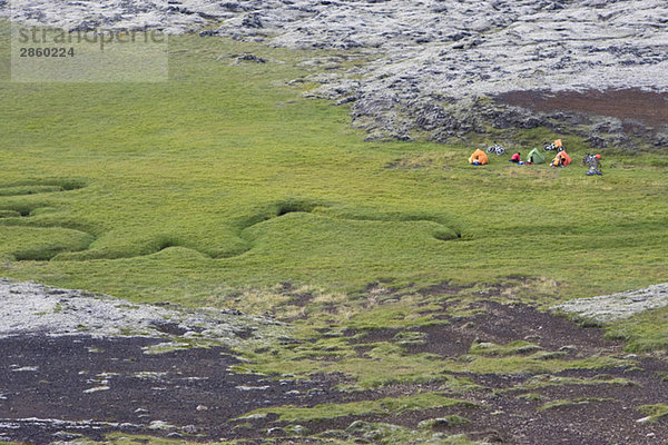 Island  Mountainbiker beim Ausruhen auf Rasen