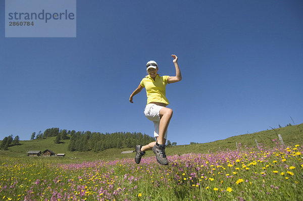 Austria  Salzburger Land  Young woman running across meadow