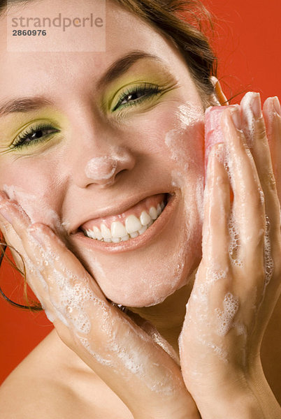 Junge Frau wäscht Gesicht mit Seife  Nahaufnahme