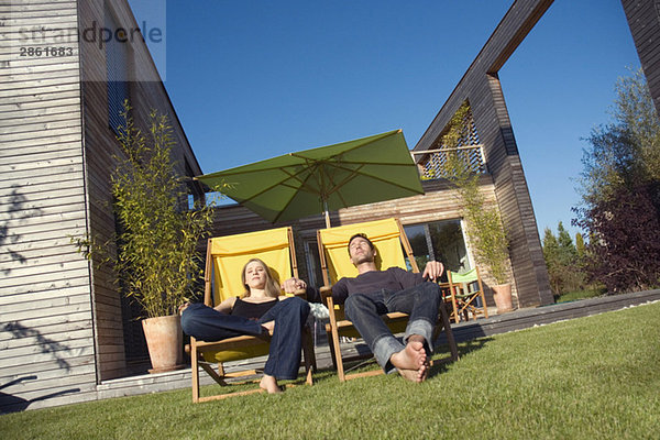 Germany  Bavaria  Munich  couple sunbathing on loungers