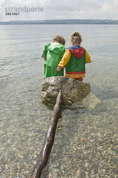 Deutschland  Baden-Württemberg  Bodensee  Kinder (3-5) im Wasser stehend  Rückansicht