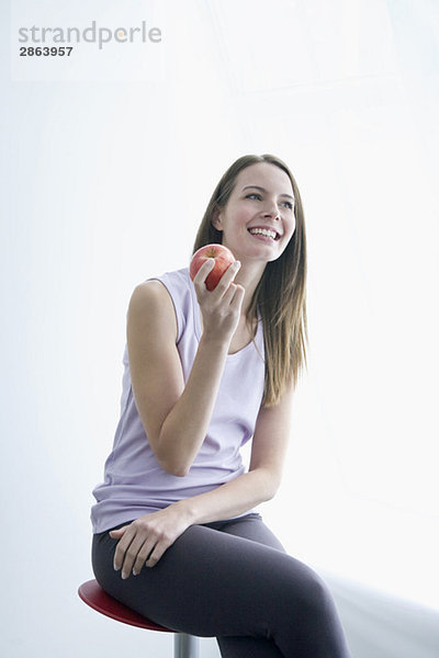 Junge Frau mit Apfel in der Hand