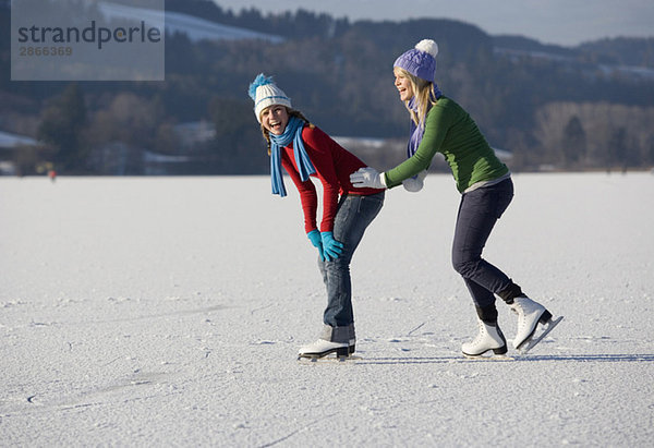 Österreich  Salzkammergut  Irrsee  Teenagerinnen (14-15) Schlittschuhlaufen  Spaß haben