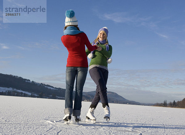 Österreich  Salzkammergut  Irrsee  Teenagerinnen (14-15) Schlittschuhlaufen und Tanzen