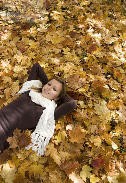 Österreich  Teenagerin (14-15)  entspannend auf Blättern Portrait  erhöhte Ansicht
