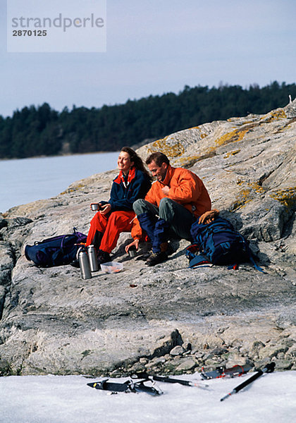 Langdistanz Skater sitzend auf einem Felsen Schweden.