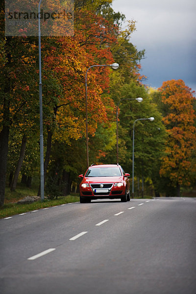 Rote Auto auf einer Landstraße Schweden.