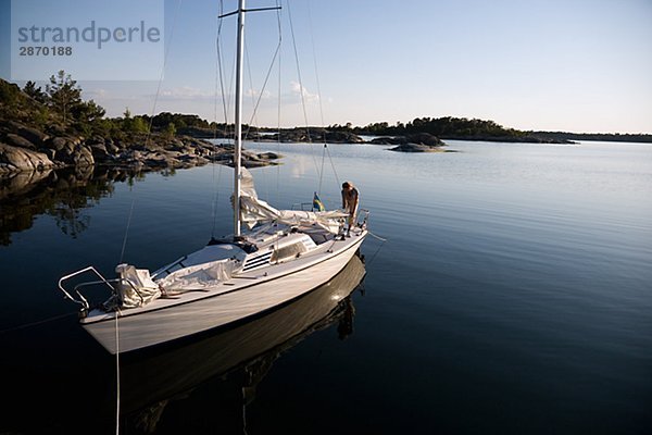 Eine Frau sitzt auf einem Segelboot Östergötlands Schweden.