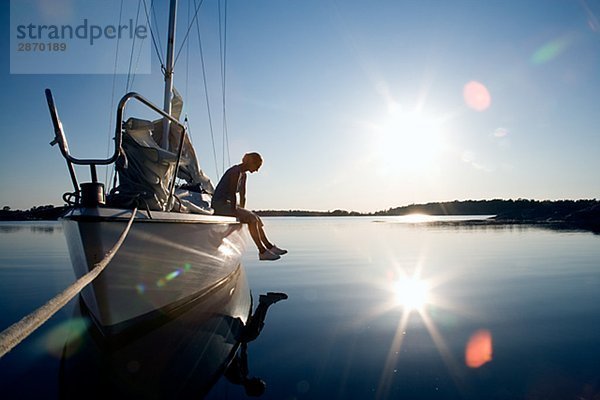 Eine Frau sitzt auf einem Segelboot Östergötlands Schweden.