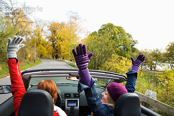 Zwei junge Frauen fahren ein Cabriolet ein Herbsttag Schweden.