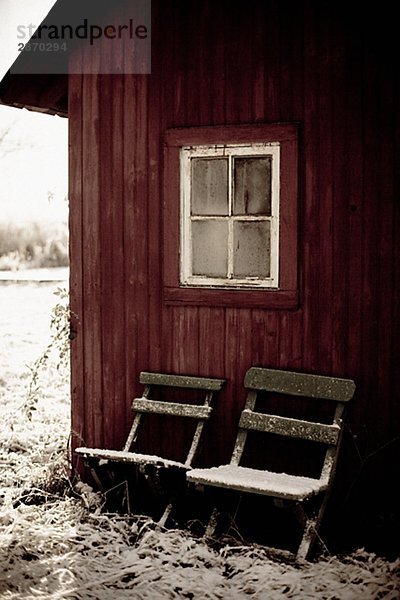 Ein rot trocken Privy und zwei verschneit Stühle Gotland Schweden.