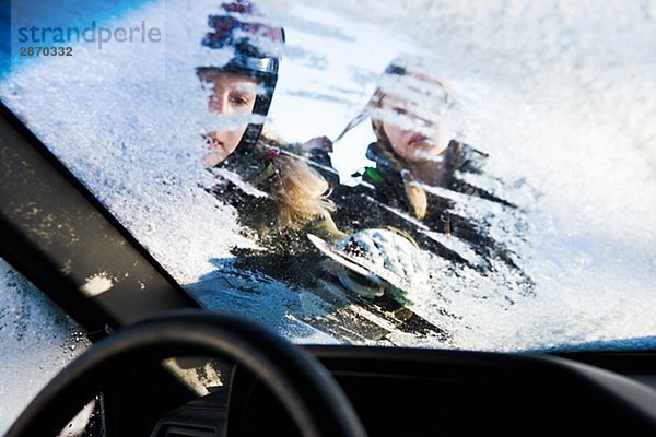 Zwei Mädchen mit einem Ice Kratzen auf ein Auto Schweden.