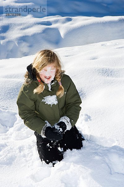 Ein Mädchen im Schnee spielen.