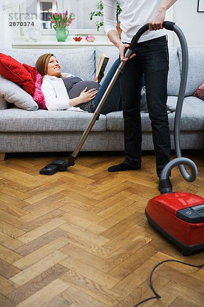 liegend liegen liegt liegendes liegender liegende daliegen Frau Mann Schwangerschaft Staubsauger Couch