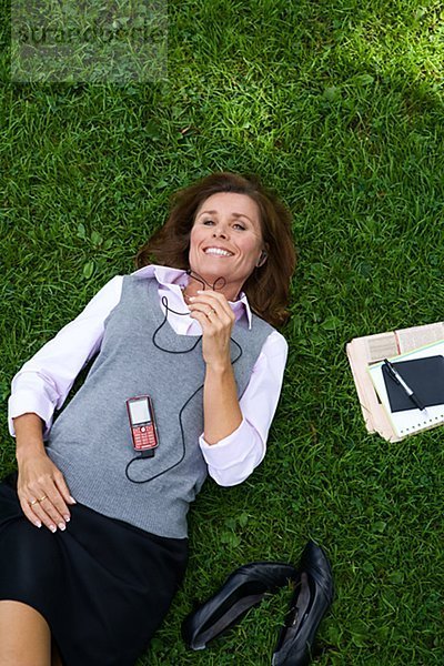 Eine Frau in einem Park mit einem Mobiltelefon Stockholm Schweden.