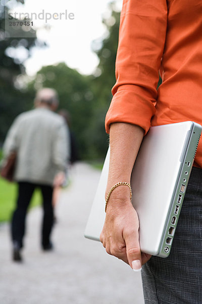 Eine Frau in einem Park mit einen Laptop Stockholm Schweden.