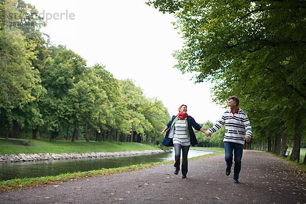 Ein paar laufen Hand in Hand im Park Schweden.