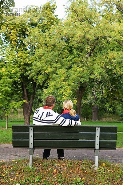 Ein paar auf einer Bank im Park Schweden sitzen.