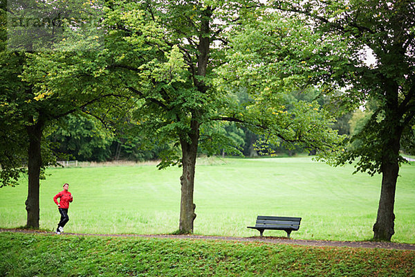 Eine Frau in einem Park Schweden Joggen.