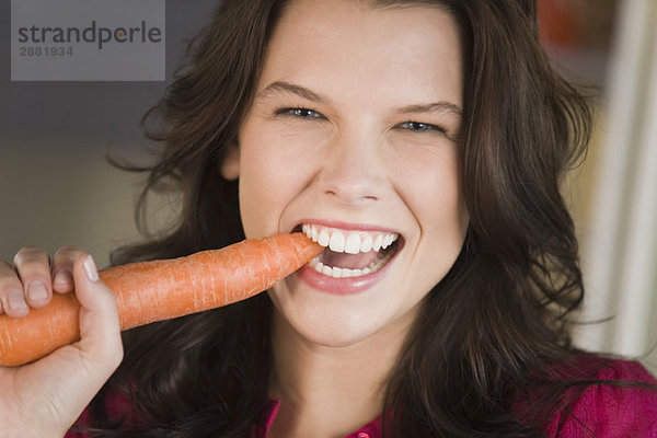 Frau beim Essen einer Karotte