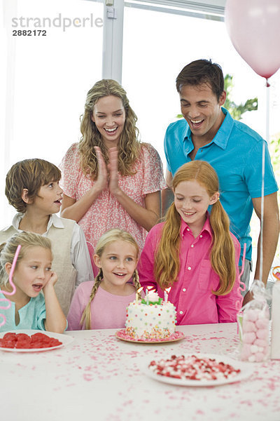 Mädchen feiert Geburtstag mit ihren Eltern und Freunden