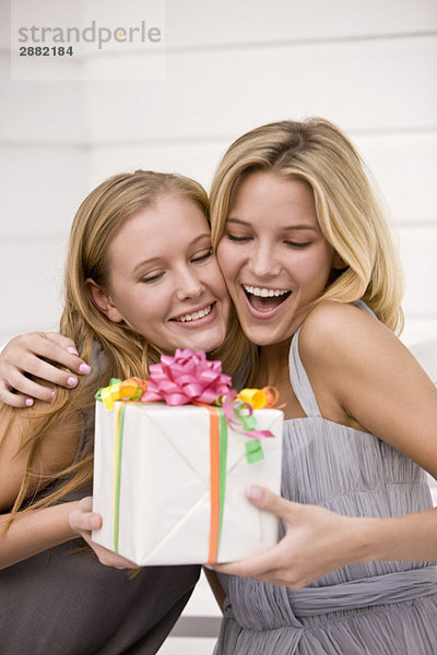 Frau schenkt ihrer Freundin ein Geschenk