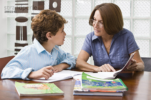 Frau hilft ihrem Enkel bei den Hausaufgaben