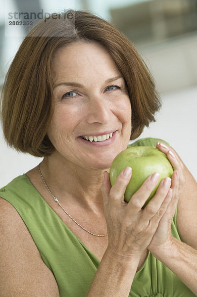 Porträt einer Frau  die einen Apfel isst