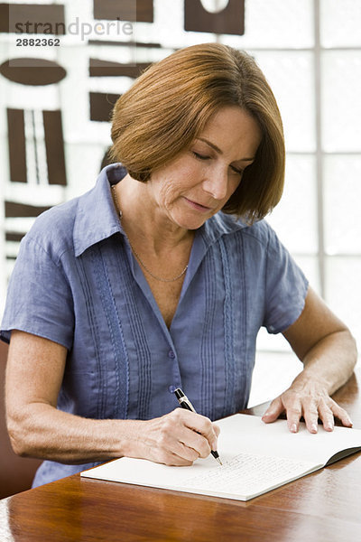 Frau schreibt in ein Notizbuch