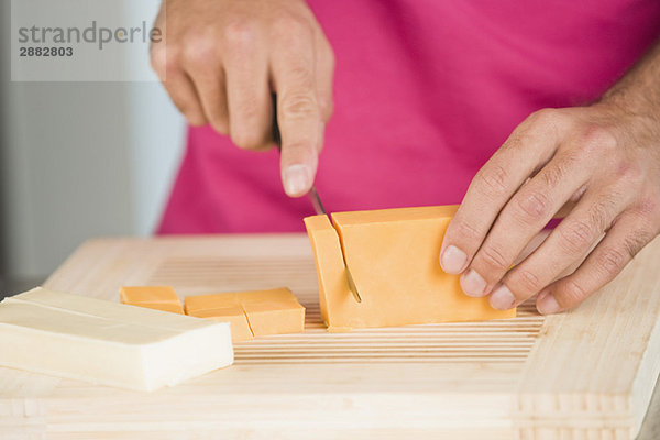 Frau schneidet Käsescheiben