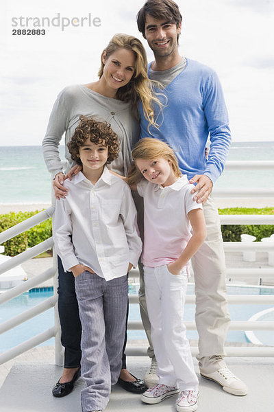 Paar mit ihren Kindern an einem Geländer stehend