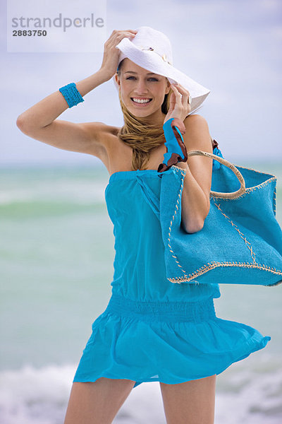 Frau mit einer Tasche am Strand