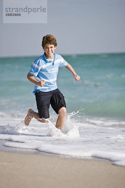 Junge  der am Strand rennt